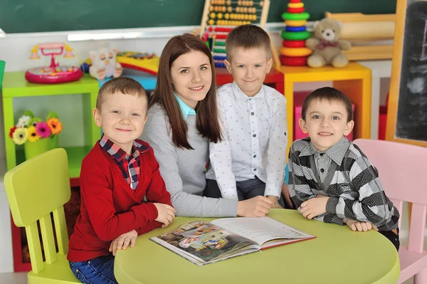 The teacher in the class plays and reads with childrens.