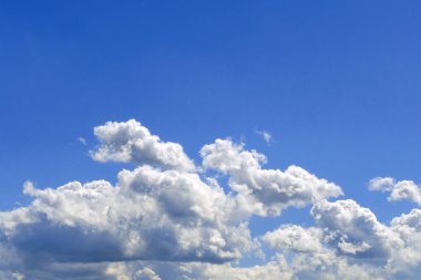 Uçsuz bucaksız mavi gökyüzünde beyaz kabarık bulutlar. Soyut doğa geçmişi. Yakın plan..