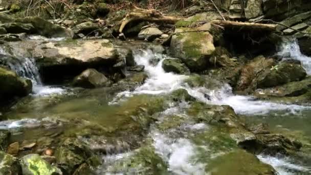 Ruisseau de montagne rapide parmi les pierres. Par une journée ensoleillée en été ou au printemps. Gros plan .