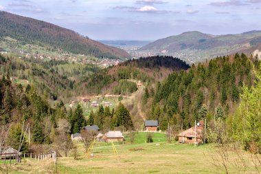 Karpat Dağları ormanları ile çevrili bir vadi içinde küçük bir köy. Yumuşak odak. Güzel plan. Açık havada.