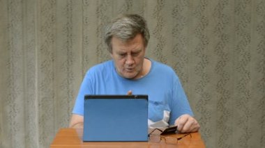 Yaşlı kişi internette bir tablet ve bir kredi kartı kullanarak satın almaya çalışır. Ama o-ebilmek değil yapmak o.