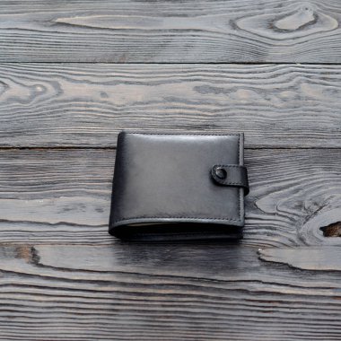 Deri elegance erkek cüzdan koyu ahşap arka plan üzerinde siyah. İnstagram biçimi. Kare. Tek nesne.