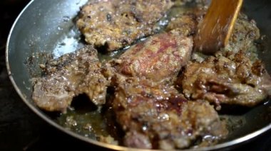 Sulu iştah açıcı sığır eti veya domuz eti veya karaciğer rostoları bir tavada. Pişirme kavramı. Yakın çekim.