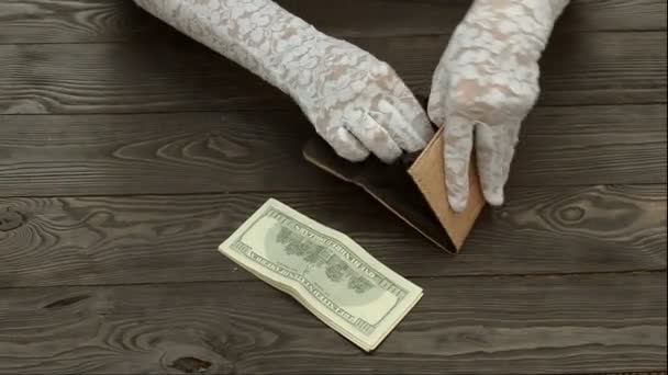 女人的手 在白色花边手套 伯爵从黑色的皮革钱包在一个黑暗的木质背景的美国美分硬币 储蓄概念 — 图库视频影像