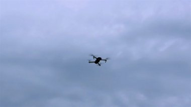 Küçük casus uçak veya quadrocopter mavi bulutlu gökyüzünde uçar. Açık havada.