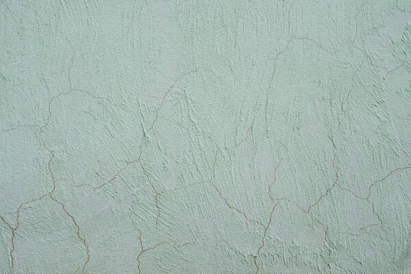 Light plaster wall with dirty scratched texture. Cracked rough abstract banner surface.  Backdrop for design. Abstract background. Close-up.