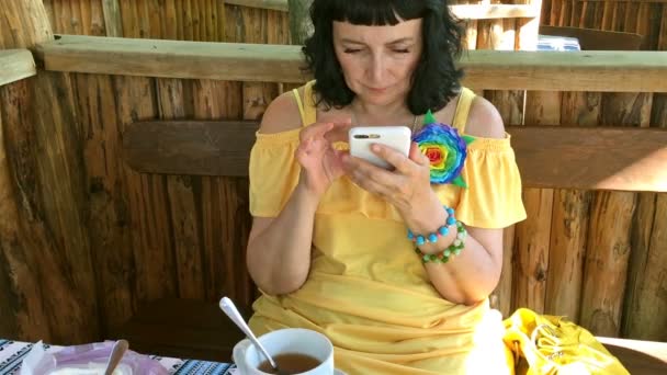 Woman Yellow Clothes Drinking Tea Street Cafe Table Using Her — Stock Video