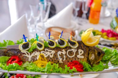 Bir dikdörtgen yemek tamamen doldurulmuş fish limon, sebze ve zeytin ile dekore edilmiştir. Geleneksel Yahudi yemeği veya ziyafet yemeği. Seçici odak. Yakın çekim.
