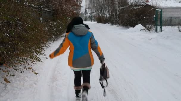 成年妇女是有趣的走在一条雪路在农村 — 图库视频影像