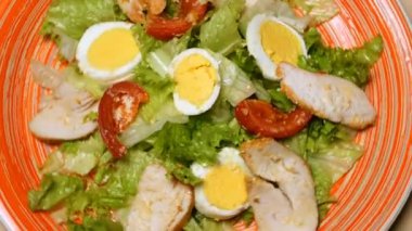 Sezar salata kırmızı plaka. Sezar salatası kavrulmuş tavuk göğsü, marul, domates, kaşar peyniri oluşur. Avrupa mutfağı ve diğer ülkelerin dünya mutfakları popüler çanak.