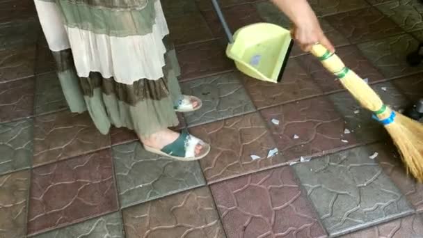 Tarefas Domésticas Mulher Varrendo Lascas Com Uma Vassoura Piso Azulejos — Vídeo de Stock