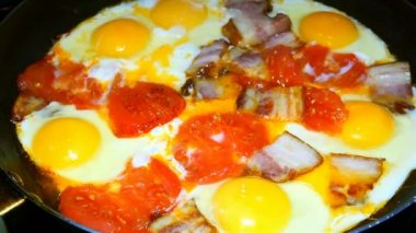 Geleneksel kahvaltı. Yumurta domates ve pastırma ile bir tavada yanmış. Sarı yumurta sarısı.