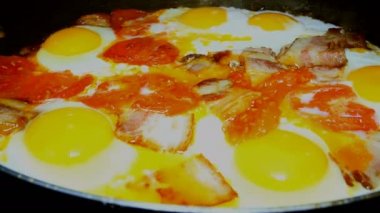 Geleneksel kahvaltı. Yumurta domates ve pastırma ile bir tavada yanmış. Sarı yumurta sarısı.