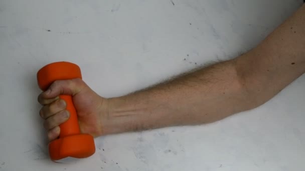 Weak Muscles Male Arm Does Exercise Orange Dumbbell Light Background — Stock Video