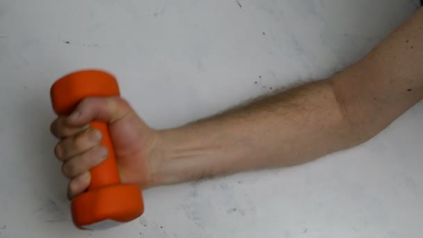 Fraco Sem Músculos Braço Masculino Faz Exercício Com Halteres Laranja — Vídeo de Stock