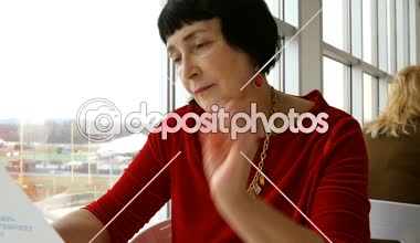 Zarif yaşlı kadın, beyaz elbise, Restoran veya kafe, büyük cam kenarında oturan menüsünü okur.