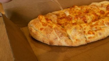 Sosis ve domates ile dolu bir karton kutu içinde yatıyor pasta plastik bıçak ve çatal ile dilimlenmiş.
