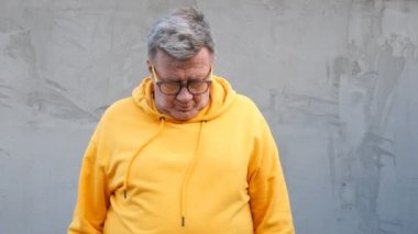 Sinirli daha parlak kıyafetler yaşlı adam, onun gözlük alır ve ağlıyor.