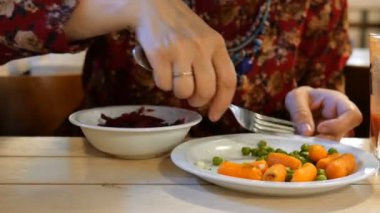 Vejeteryan yemekleri. Yemek sonrası sırasında. Kadın vejetaryen yemeği yiyor. Farklı sebzeler. Bir kafede veya restoranda. Close.