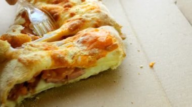 Sosis ve domates ile dolu bir karton kutu içinde yatıyor pasta plastik bıçak ve çatal ile dilimlenmiş.