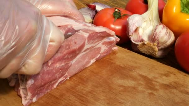 生肉牛排是从一大块猪肉或牛肉在木切板上切下来的 西红柿 — 图库视频影像