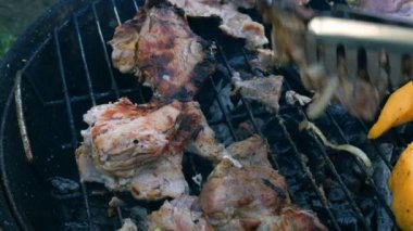 Dilimlenmiş et biftek parçaları bir metal ızgara üzerinde bir barbekü kömürler üzerinde ızgara ve et maşa ile teslim edilir.