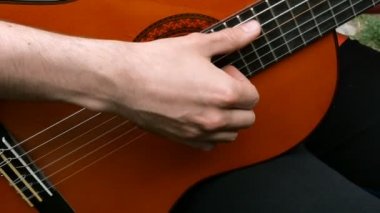 Performans müzisyeni. Gitarist akustik ahşap gitar parmaklarıyla oynar. Açık havada. Close.
