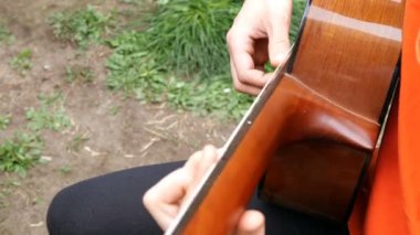 Performans müzisyeni. Gitarist akustik ahşap gitar parmaklarıyla oynar. Açık havada. Close.