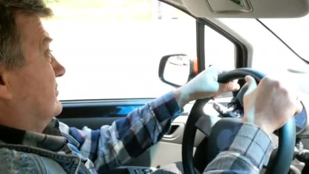 Adult Man Drives His Car Turns Steering Wheel Looks Ahead — Stock Video