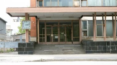 Kiev, Ukrayna, Mayıs 2019: - Şehrin eteklerinde, merdiven ve saat ile eski terk edilmiş ofis binasının cephesi ve girişi.