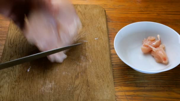 自制烹饪 人手将鸡胸片切成小块 放在木质切割板上 放入白色陶瓷碗中 — 图库视频影像