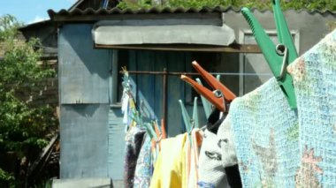 Ev işi. Yıkanmış rahat giysiler ve farklı keten, köyde döken yanında arka bahçesinde bir çamaşır ipi asılı.