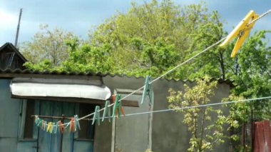 Ev. Çok renkli plastik clothespins, köyde döken yanında arka bahçesinde bir çamaşır ipi asılı.