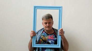 Komik üst düzey adam-freak portre çerçevesinden görünüyor ve dil gösterir. Kameraya bakmak ve yüzleri yapmak veya grimacing.