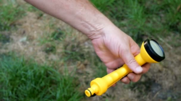 ホームガーデニング 人間の手は 新しい緑色のゴムホースに黄色の庭の噴霧器を挿入します — ストック動画