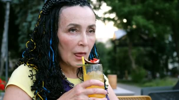 Senior Extravaganta Kvinna Dricker Passion Frukt Cocktail Sitter Ett Gatukafé — Stockvideo