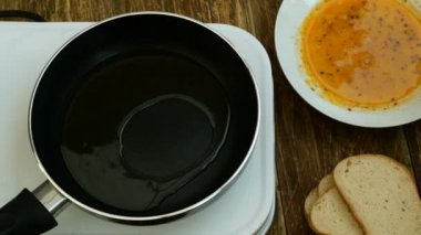 Ev yapımı mutfak. Croutons veya beyaz ekmek tost, dövülmüş bir tavuk yumurtası batırılmış, küçük bir elektrikli soba üzerinde kızartma için bir tavada kızartılır.