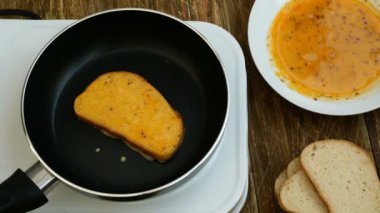 Ev yapımı mutfak. Croutons veya beyaz ekmek tost, dövülmüş bir tavuk yumurtası batırılmış, küçük bir elektrikli soba üzerinde kızartma için bir tavada kızartılır.
