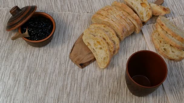 Velsmagende morgenmad. Friskt brød med syltetøj og mælk. Mælk hældes i en kop. Toast med frugt marmelade på serviet. Afbalanceret mad. Rustik stil. Brød og mælk tages i hånden . – Stock-video