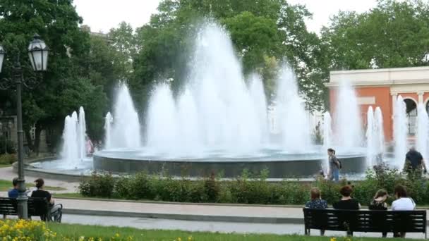 Odessa, Ucrania, junio 2019: - Ocio de verano. Personas sentadas y la relajación en un banco, cerca de la fuente de agua en el parque en el cálido día de verano en Odessa Ucrania . — Vídeo de stock