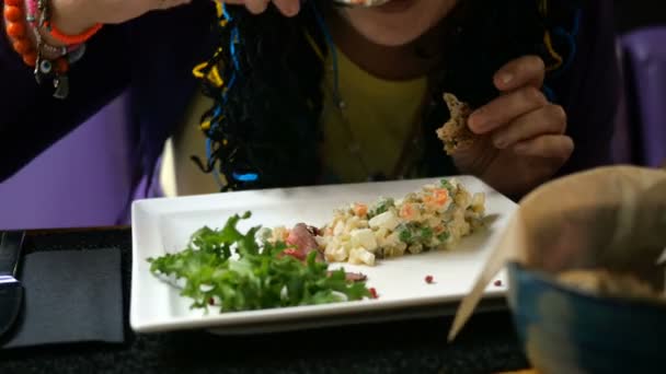 Tasty dinner. Human eating traditional salad for slavic peoples Olivier or salad with vegetables and meat in cafe or restaurant from white plate. — Stock Video