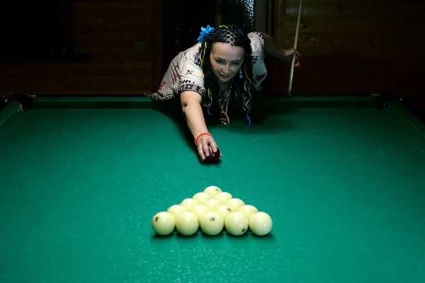 Senior woman break the in triangle billiard balls, on billiard t