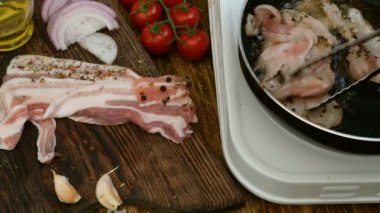 Ev yapımı yemek. Bir mutfak tavada domuz eti veya sığır eti kavurma et tongs ile dönüşmüştür. Domates, soğan, sarımsak. Rustik tarzı.