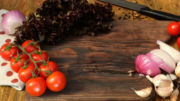 Cozinha caseira. Produtos para comida deliciosa. As mãos humanas põem o porco cru fatiado ou o peito de vaca no conselho de cozinha de madeira, tomates de verduras, alface, cebola, alho. Em estilo rústico . — Vídeo de Stock