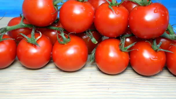 Pomodori ciliegia sui rami che si trovano sulla tavola da cucina cospargere o versare acqua o prodotti chimici. Può essere trattato prima dell'uso. Gocce su pomodori . — Video Stock