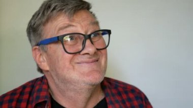 Eksantrik kıdemli adam, gri Saç ile bir balon şişirilir, sonra deldi ve patlar ve yüksek sesle çığlıklar, onun dişsiz ağzını geniş açarak. Yakın çekim portre.