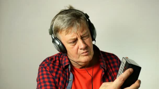 Homem Idoso Adulto Expressivo Ouvindo Rádio Antigo Está Procura Diferentes — Vídeo de Stock