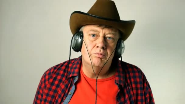 Expresivo Adulto Mayor Con Sombrero Vaquero Escucha Música Sus Auriculares — Vídeo de stock