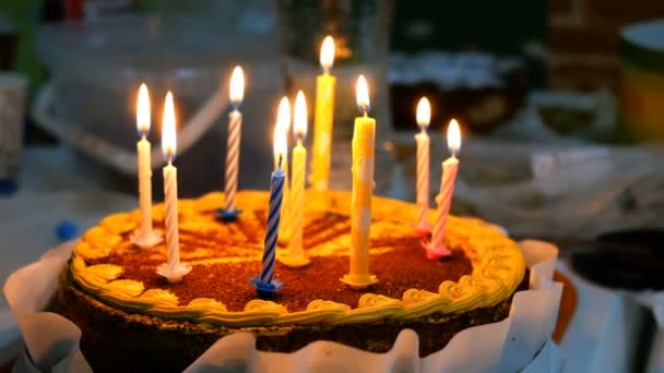 漂亮的美味生日蛋糕与燃烧的蜡烛是在厨房的桌子上 也许这是为庆祝生日准备的 选择性聚焦 — 图库视频影像