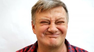 Gri saçlı yaşlı adam başını grimaces ve olumsuz jest yapar. Canlı yüz ifadeleri. Close.